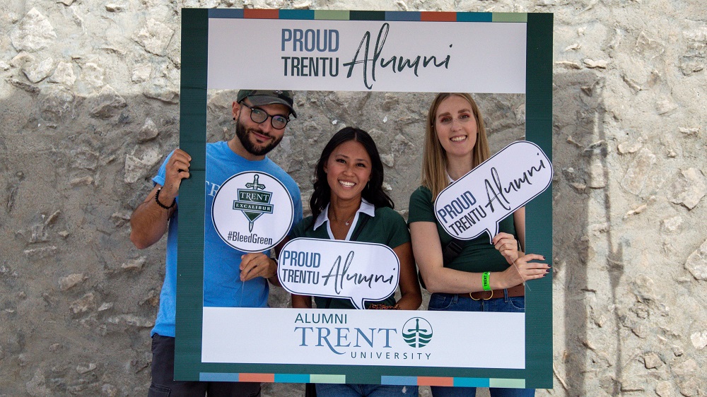 Three people in Proud Trentu Alumni Sign