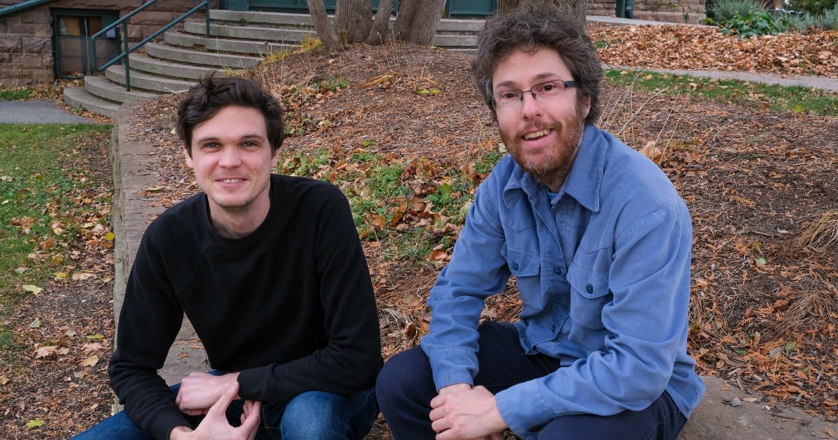 Two individuals sitting on a bench