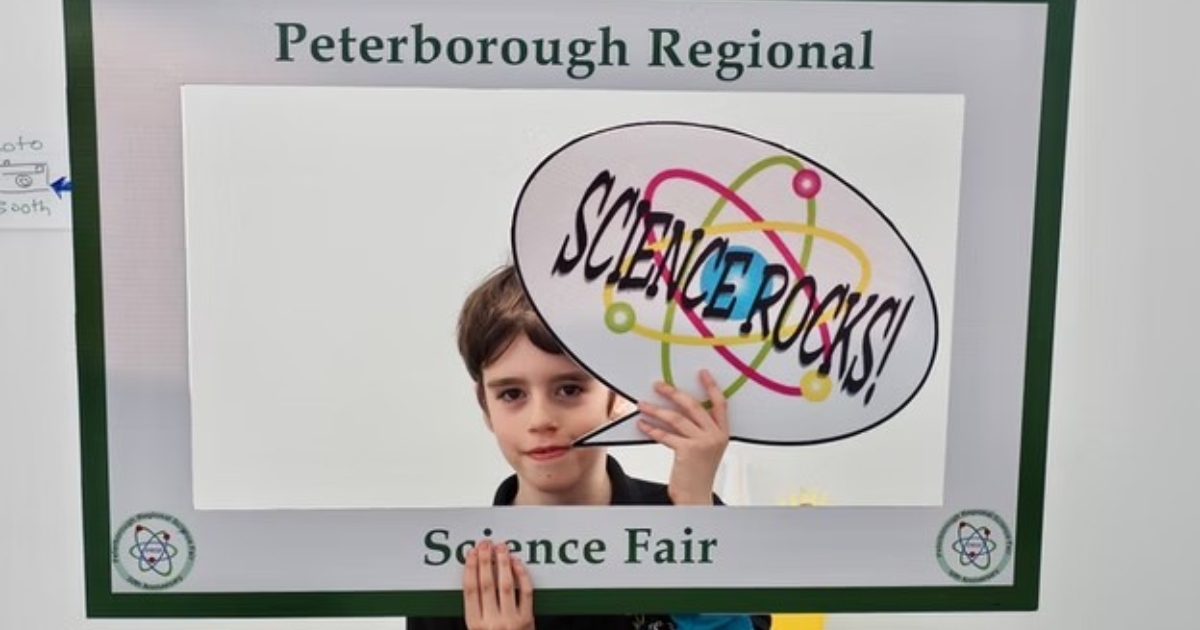 A kid holding the Science Rocks sign