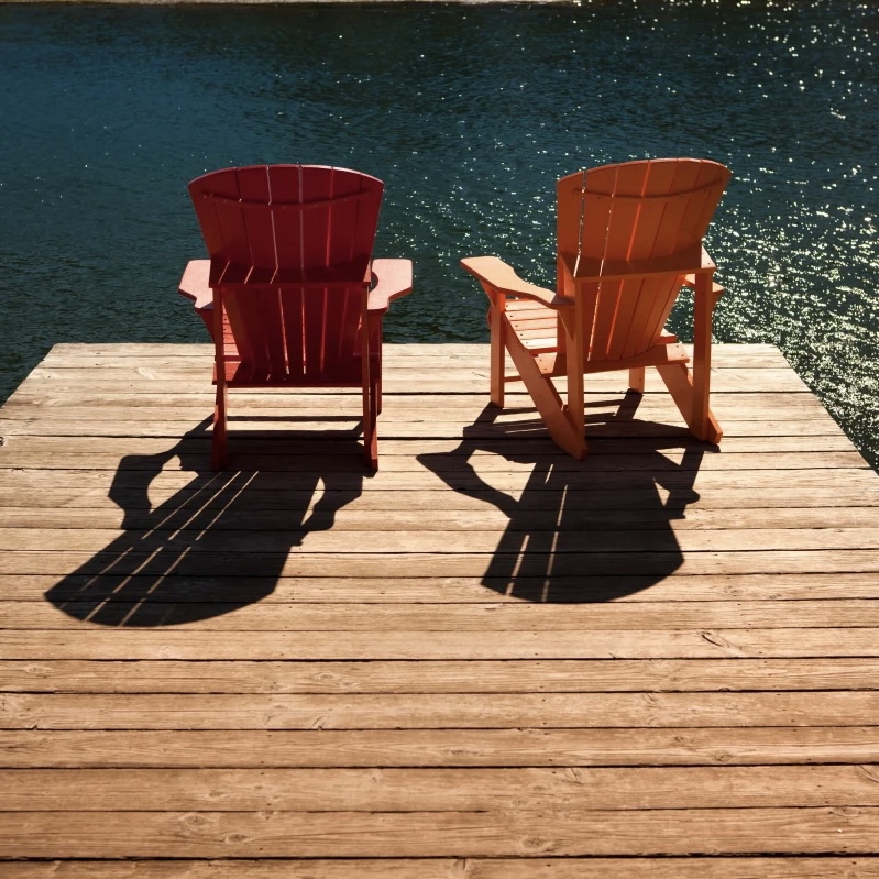 Muskoka chairs on a dock.