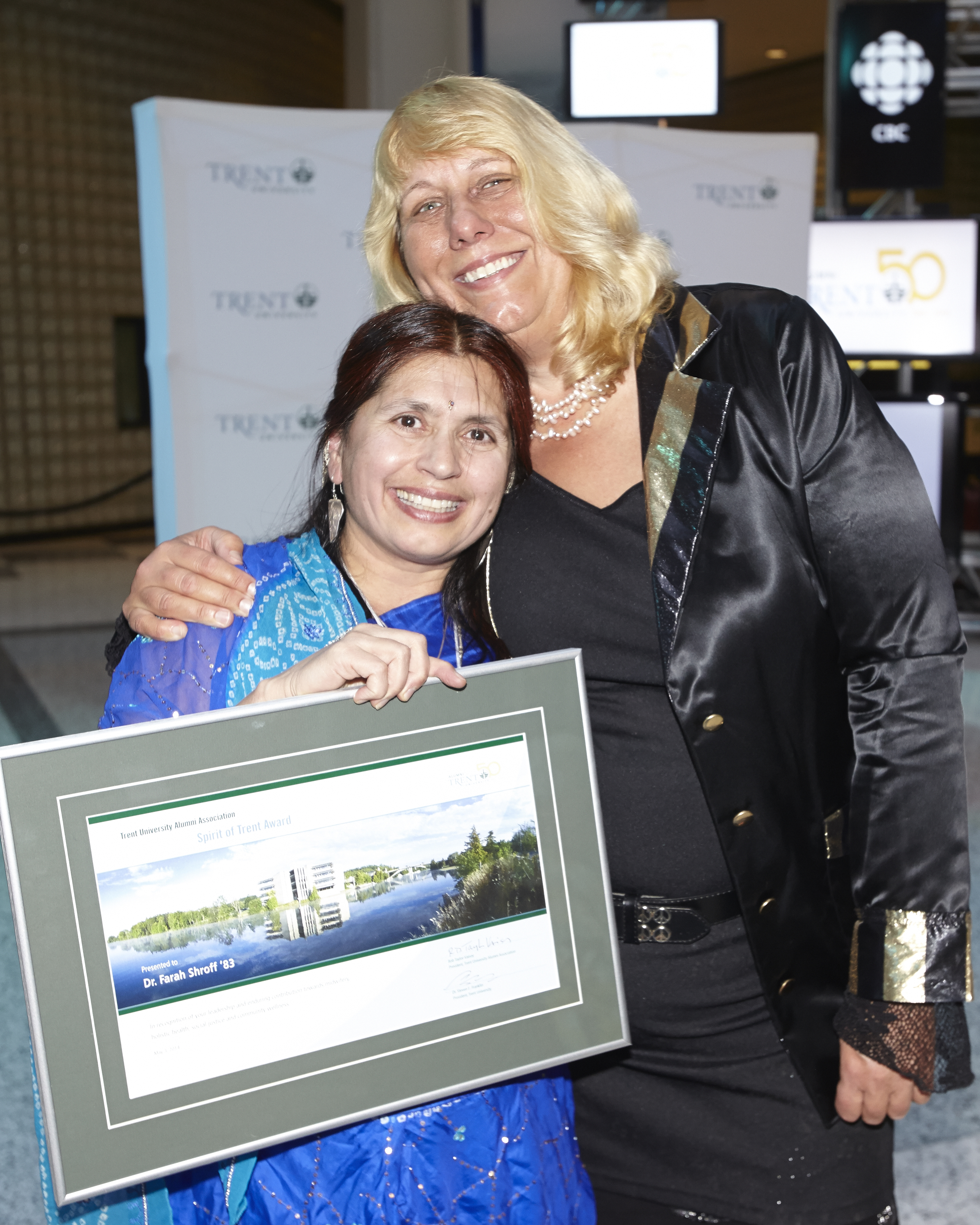 Two Alumni Award Recipient holding a framed picture of Trent University