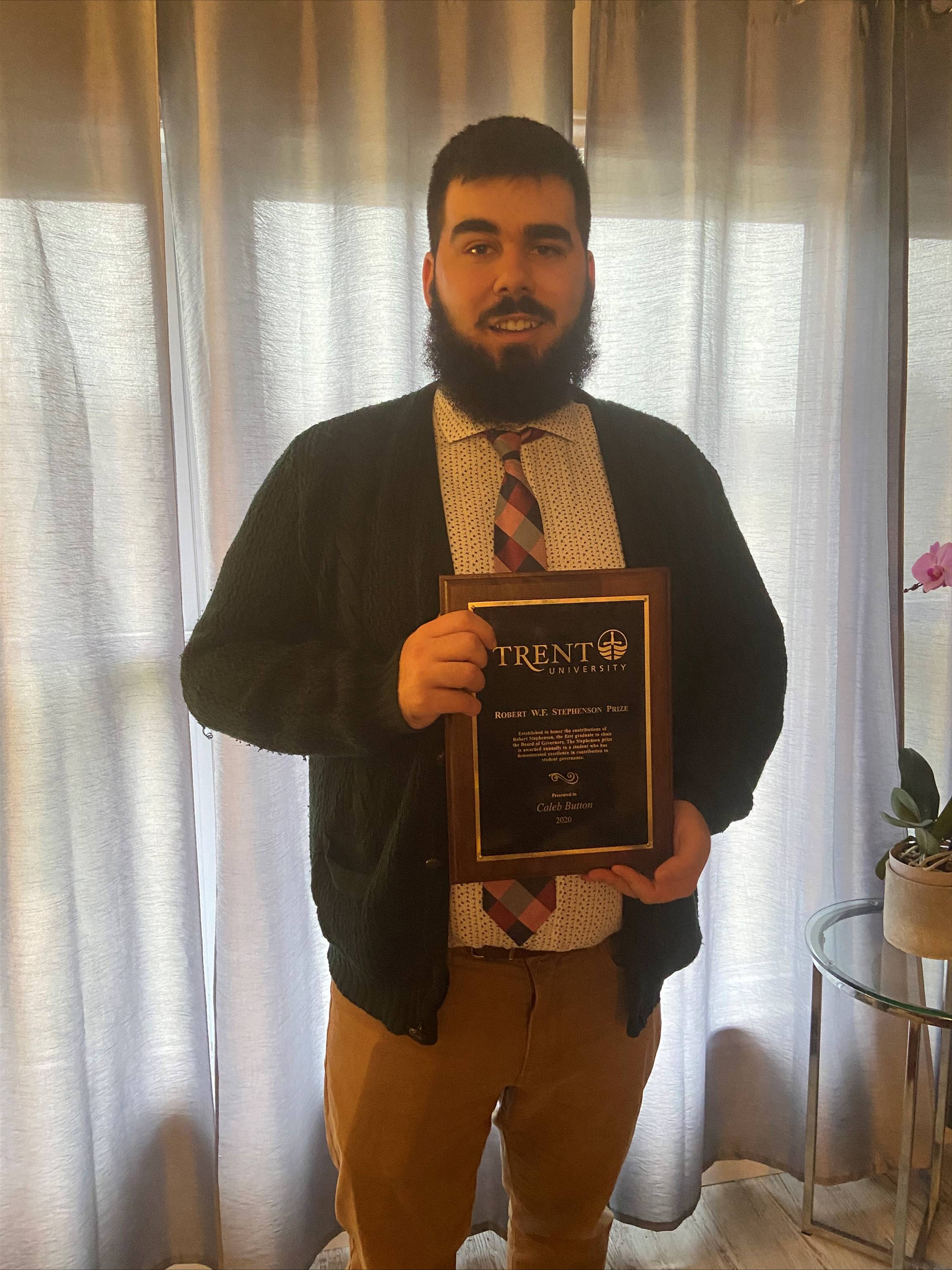 caleb button with an award