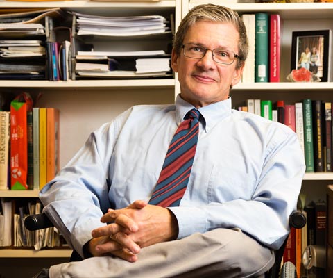 James Retallack sitting in front of a bookshelf.