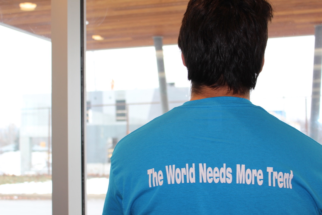 a student with his back facing the camera who's shirt reads "The world needs more Trent"